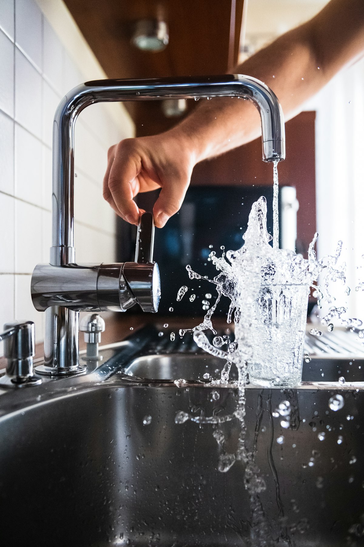 Chrome mixer tap running into a stainless steel sink